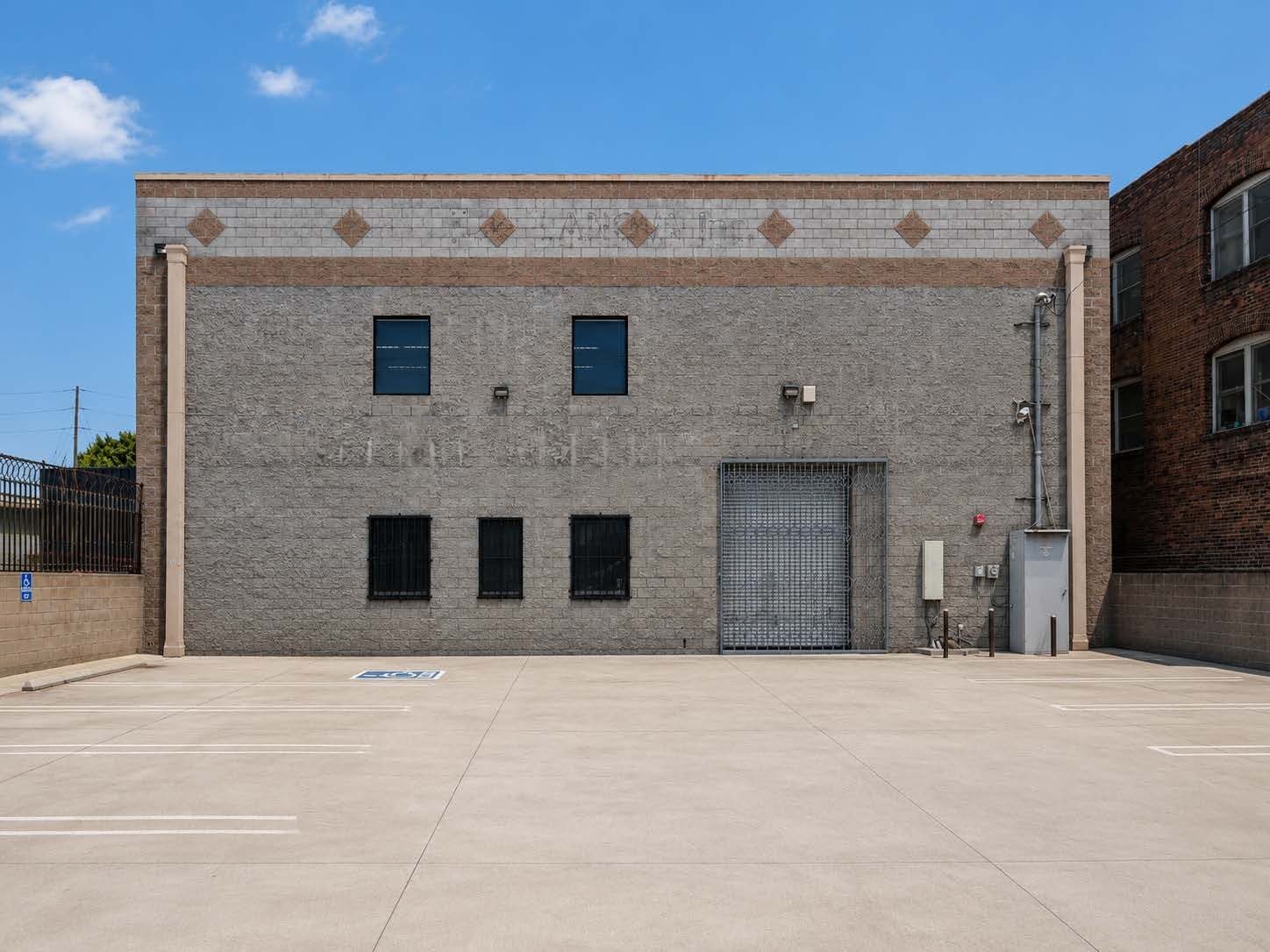 2120 S Main St — two-story concrete-block warehouse facade with secured loading entrance and yard